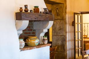 Il dispose d'une cuisine avec une cheminée en briques et des vases. dans l'établissement Öreghegyi Bika Panzio, à Székesfehérvár