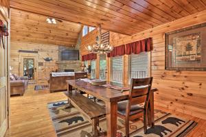 a dining room with a wooden table in a cabin at Woodsy Retreat with Hot Tub, 8 Mi to Dollywood! in Sevierville