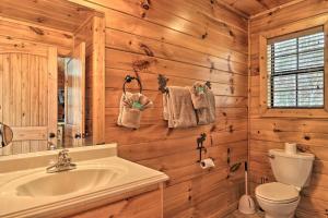 a bathroom with a sink and a toilet and wooden walls at Woodsy Retreat with Hot Tub, 8 Mi to Dollywood! in Sevierville +23 photos