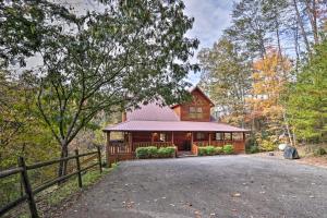 a cabin in the woods with a fence at Woodsy Retreat with Hot Tub, 8 Mi to Dollywood! in Sevierville
