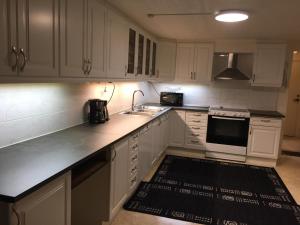 een keuken met witte kasten, een wastafel en een fornuis bij Beutiful house with large garden . in Lilla Edet +33 foto's