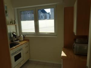 cocina con ventana, fregadero y fogones en City Apartments en Krefeld