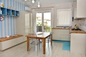a kitchen with a table and chairs in a room at Appartamento le calette in Stazzo