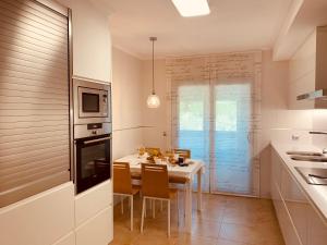 kuchnia ze stołem z krzesłami i jadalnią w obiekcie SANXENXO SUITES CON VISTAS Muy Bien Ubicado w mieście Sanxenxo