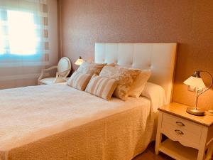 sypialnia z łóżkiem, krzesłem i oknem w obiekcie SANXENXO SUITES CON VISTAS Muy Bien Ubicado w mieście Sanxenxo
