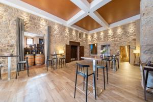 uma sala de degustação com paredes de pedra e bancos de bar em Castilla Termal Monasterio de Valbuena em Valbuena de Duero