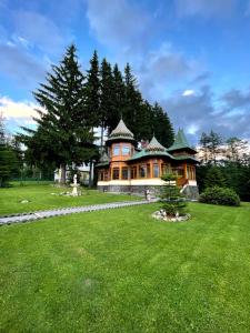 duży dom z zielonym trawnikiem przed nim w obiekcie Vila Sonja w mieście Predeal