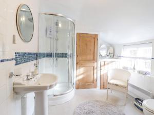 a white bathroom with a shower and a sink at Wayside Cottage in Bedford +27 photos