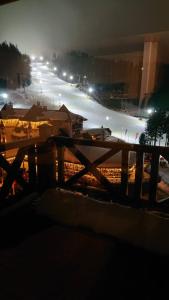 a view of a street at night with a fence at Vučko Apartman U532 in Jahorina