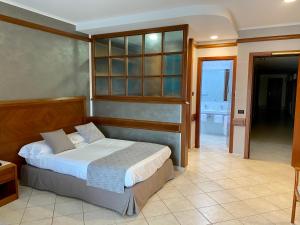 a bedroom with a bed and a door to a bathroom at Hotel Le Palme in Paestum