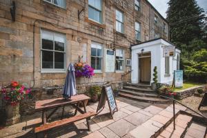 a building with a table and an umbrella outside at Alston House Hotel in Alston