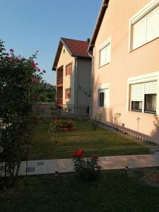 ein Haus mit einem Hof davor in der Unterkunft Apartmani Astra in Vukovar