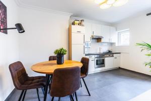 a kitchen and dining room with a wooden table and chairs at Experience Central Vienna from a Stylish and Modern Apartment in Vienna