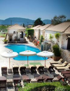 - une piscine avec des tables, des parasols et des chaises dans l'établissement The residence at Garden Village, à Kalamaki