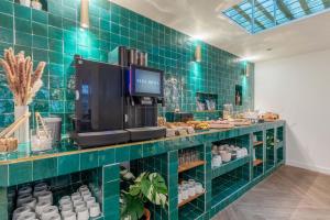 una tienda con una pared de azulejos verdes y una cafetería en 1924 Hôtel en Grenoble