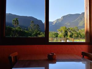 a room with two windows with a view of mountains at Pousada Malacara in Praia Grande
