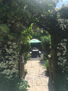 un giardino con tavolo e ombrellone di The Hawthornes Licensed Guest House a Knottingly