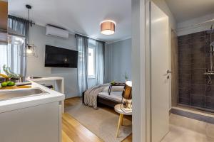 uma casa de banho com um lavatório e uma cama num quarto em Adria Square Studios em Rijeka