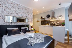 - une chambre avec un lit et un mur en briques dans l'établissement Adria Square Studios, à Rijeka