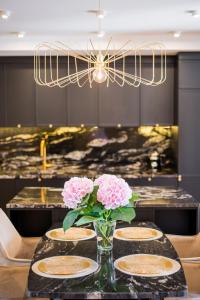 Luksusowy penthouse z jacuzzi i widokiem na morze في غدينيا: طاولة مع أربعة أطباق و مزهرية مع الزهور الزهرية