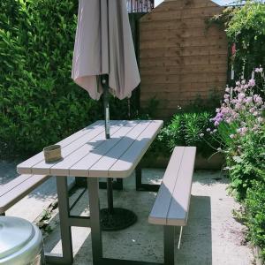 a picnic table with an umbrella and a bench at The Hawthornes Licensed Guest House in Knottingly