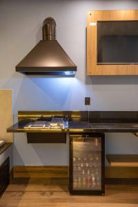 a kitchen with a counter with a stove top oven at Drops Motel Campinas in Campinas