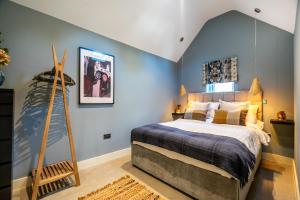 una camera da letto con un grande letto con pareti blu di Bay Tree Cottage a York