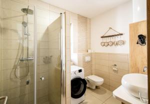 uma casa de banho com um chuveiro, um WC e um lavatório. em Apartmaji BANONIA " Štorkljin let " em Banovci