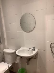 ein Badezimmer mit einem Waschbecken, einem WC und einem Spiegel in der Unterkunft CR.HOTEL in Makkasan