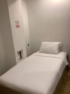 a white bed with a pillow on top of it at CR.HOTEL in Makkasan