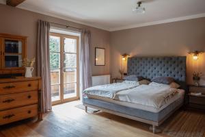 um quarto com uma cama, uma cómoda e uma janela em Ferienwohnungen Zipflwirt em Bayrischzell