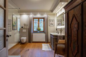 a bathroom with a sink and a toilet and a window at Ferienwohnungen Zipflwirt in Bayrischzell