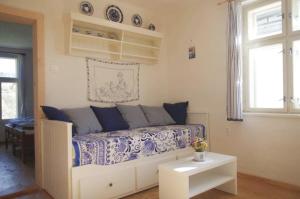 ein Wohnzimmer mit einem Bett mit blauer und weißer Bettwäsche in der Unterkunft Vopařilův statek Leština in Litomyšl