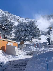 grupa ludzi siedzących w śniegu w obiekcie Fantastic brand new apartment in best location just few steps from the ski slope! private parking w mieście Sierra Nevada