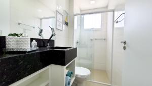 a white bathroom with a shower and a toilet at Residencial Renata - Apartamento na Praia de Palmas - 3 dormitórios a 300m da Praia in Governador Celso Ramos +14 photos