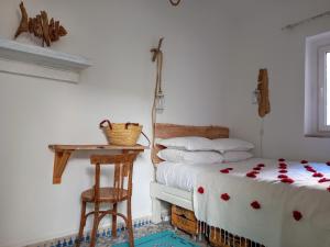 sypialnia z 2 łóżkami, stołem i stołkiem w obiekcie Hôtel Emeraude Essaouira w mieście As-Suwajra