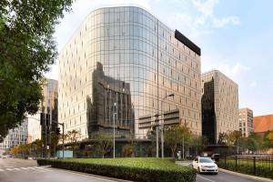 een auto geparkeerd voor een glazen gebouw bij Hyatt House Shanghai Hongqiao CBD in Shanghai