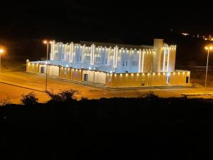 a white building with lights on it at night at شاليهات اليخت بالبشائر in Al Qārah