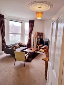 uma sala de estar com um sofá e uma mesa em Bright, character 3 bed Apartment: 7 mins walk to sea em Portsmouth
