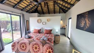 a bedroom with a bed and a large window at THE BAOBAB BUSH LODGE, no self catering in Hoedspruit