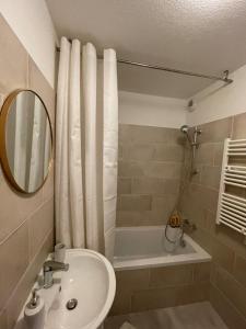 La salle de bains est pourvue d'un lavabo, d'une douche et d'un miroir. dans l'établissement Superbe appartement au calme avec vue sur le Lac., à Évian-les-Bains