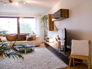 - un salon avec un canapé et une télévision dans l'établissement Ferienwohnung Magnolie, à Überlingen