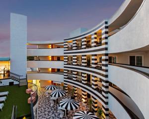 an apartment building with a lobby with tables and chairs at Carlyle Inn in Los Angeles