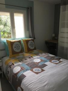 a bed with a quilt on it in a bedroom at Rêve de Thau in Balaruc-le-Vieux