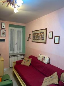 een woonkamer met een rode bank en een raam bij Appartamento in Borgo storico (San Vito Romano) in San Vito Romano