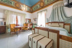 a bedroom with a bed and a table and a desk at Villa Mariella Pittorino - camere in B&B in Leni