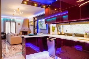 a kitchen with purple cabinets and a living room at Efis guest house near Nafpaktos-Fully Equipped Home in Nafpaktos