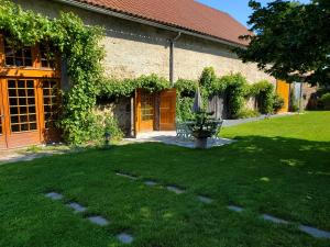 a house with a grass yard with a bench in front of it at Domaine des Maillets in Blot-lʼÉglise