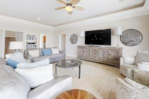 a living room with a couch and a tv at Windswept by Meyer Vacation Rentals in Gulf Shores