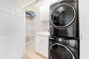 a black washer and dryer in a white kitchen at Windswept by Meyer Vacation Rentals in Gulf Shores +28 photos